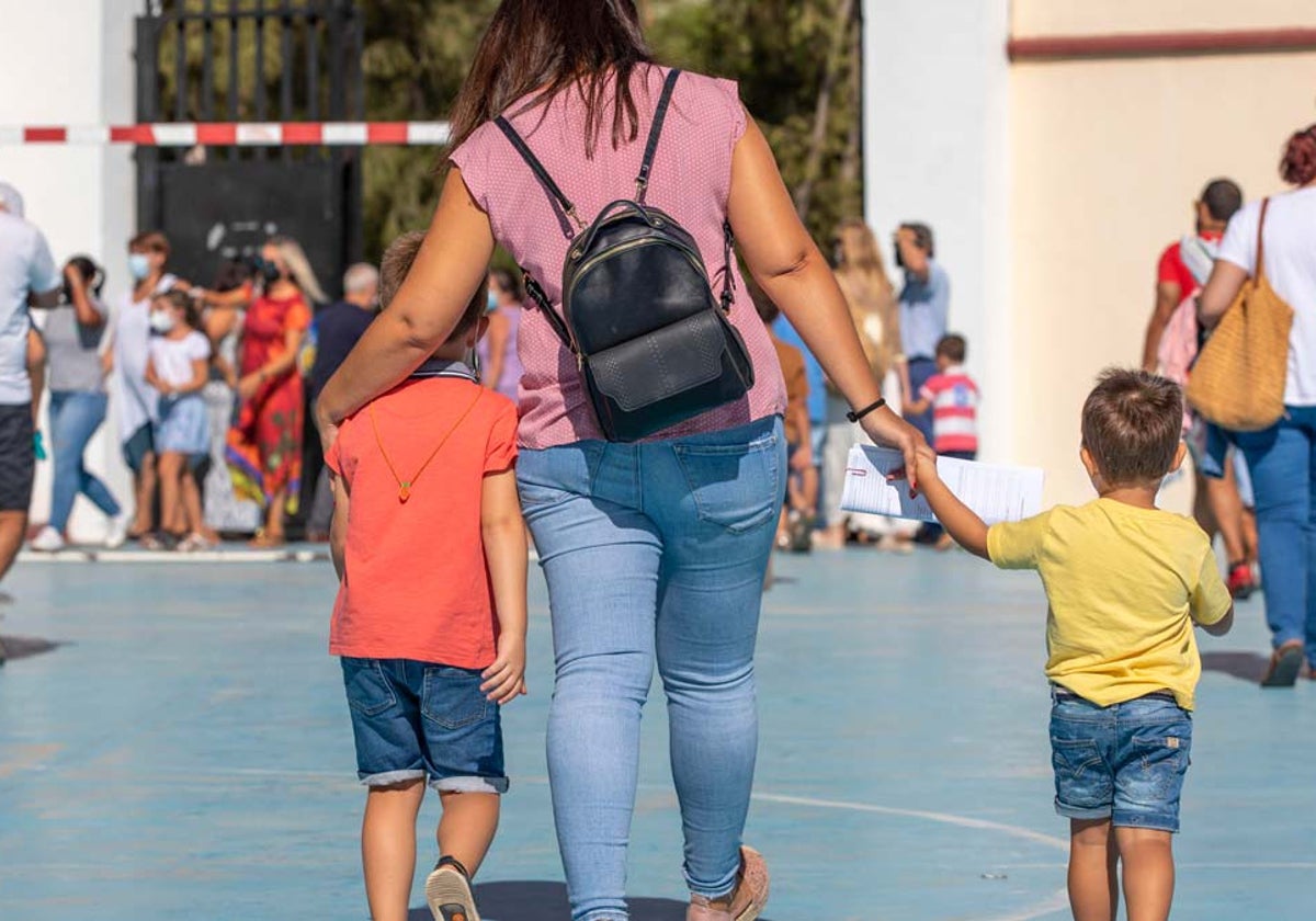 Una madre acompaña a sus hijos al colegio