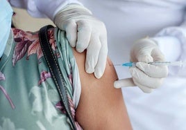 Una mujer se vacuna de la gripe en un centro sanitario