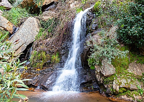 Imagen secundaria 1 - Senderistas por la Sierra de Aracena, cascada en Santa Ana la Real y libro abierto en mitad de la naturaleza.
