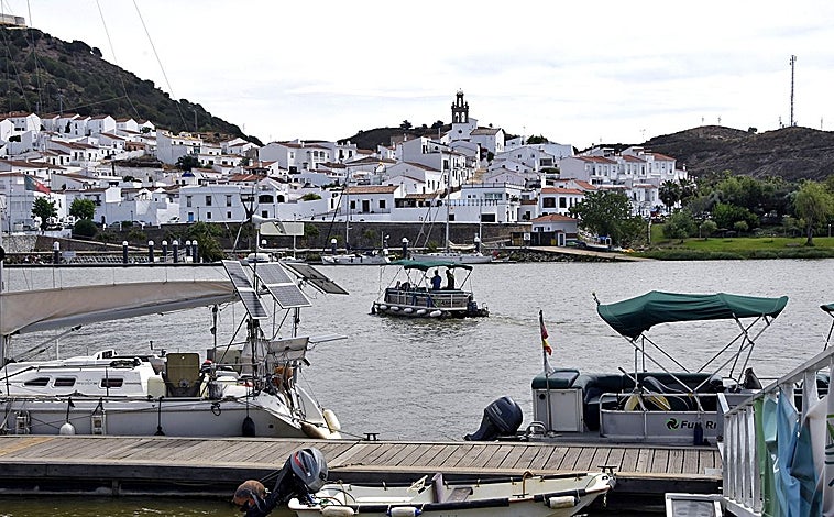 Imagen principal - Una panorámica de Sanlúcar de Guadiana y abajo de sus molinos, mientras que a la derecha aparecen casas de Alcoutim