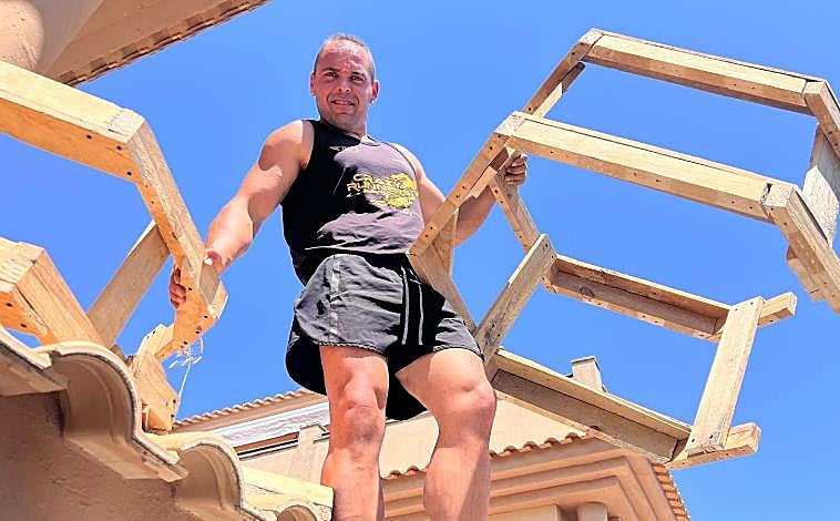 Imagen principal - Daniel Nogales en pleno trabajo creando la casa del Grinch y abajo detalles de cómo está quedando todo en dicha calle de Corrales