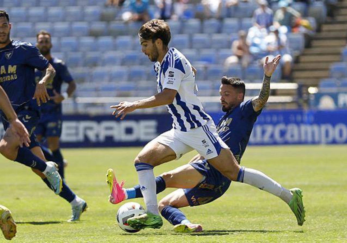 Javi Ajenjo conduce el balón obstaculizado por un rival