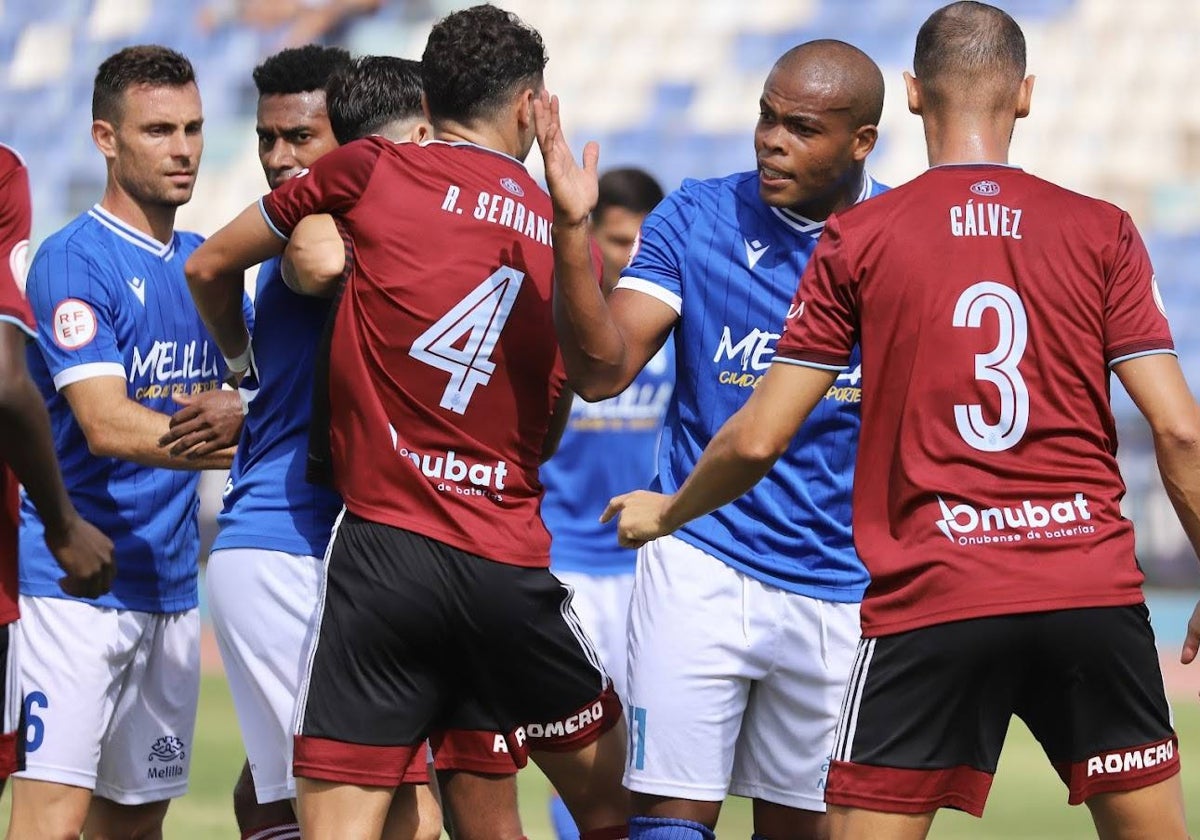 Rubén Serrano y Alejandro Gálvez vigilando de cerca a Vinicius Tanque durante el Melilla-Recreativo