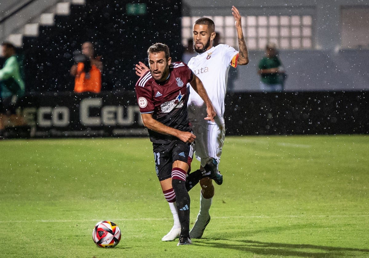 Antoñito defendido por un rival en el Ceuta-Recreativo disputado en el estadio Alfonso Murube