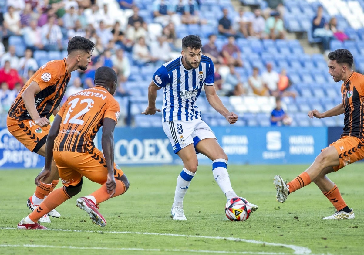 Luis Alcalde presionado por varios adversarios en un lance del Recreativo-Antequera