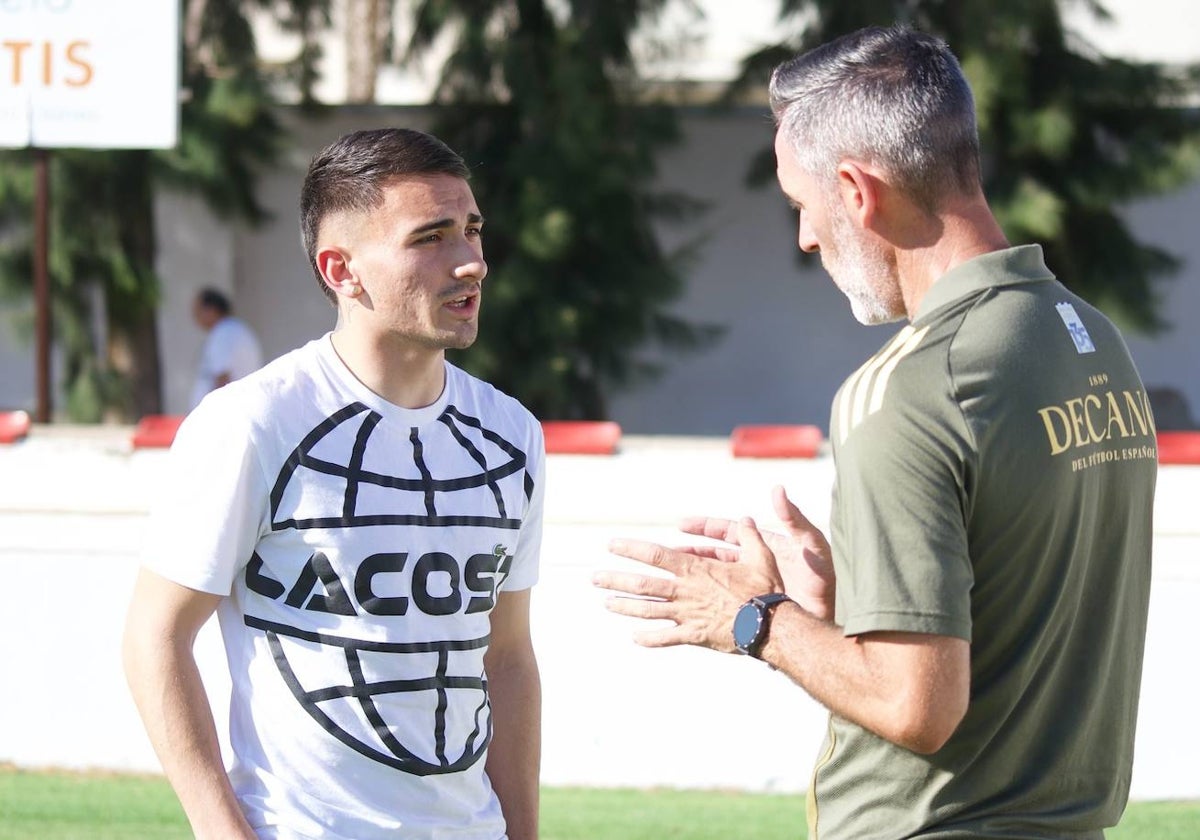 Abel Gómez conversando con Juan Cerrudo en el césped del Municipal de Chiclana
