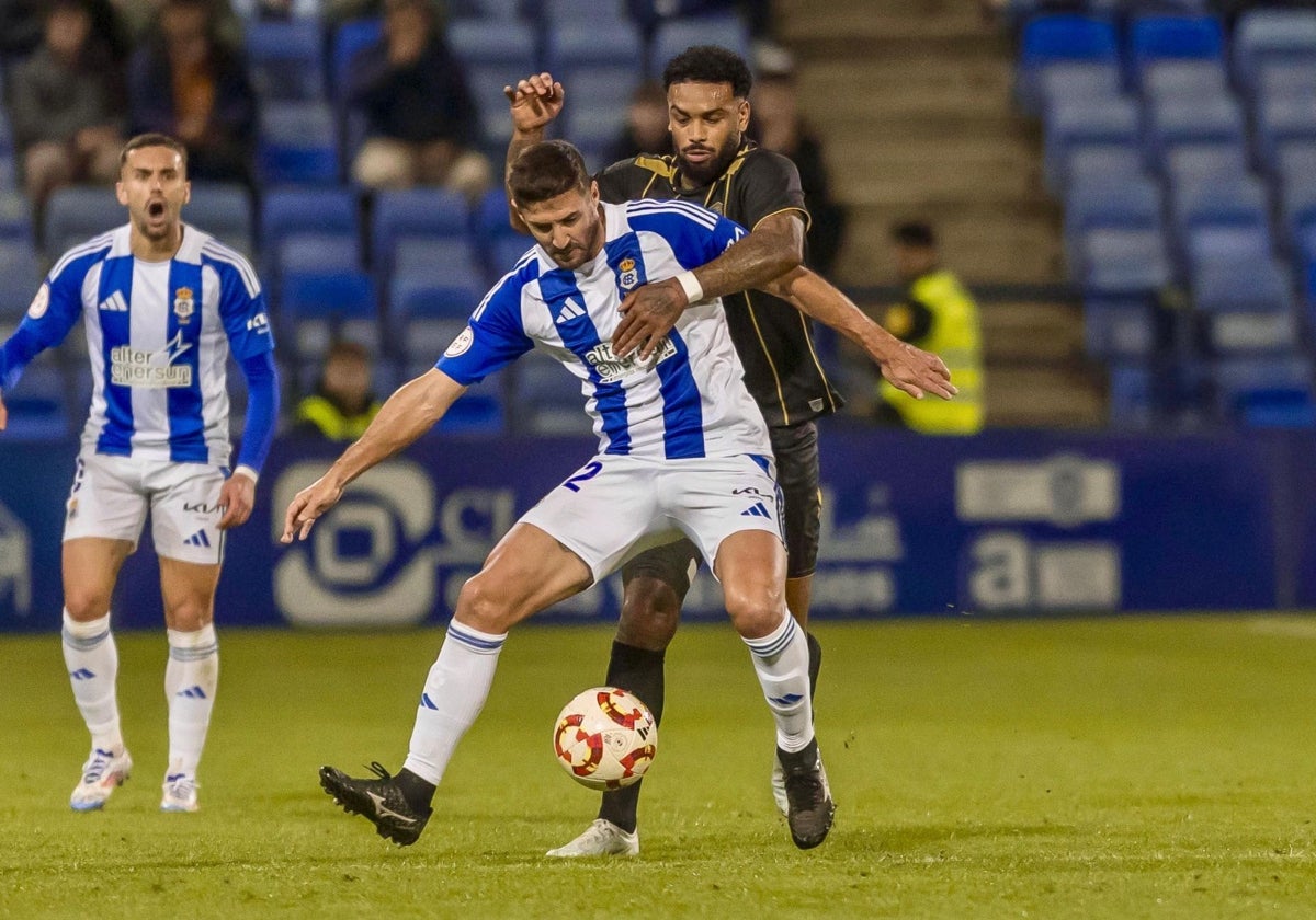 Raúl Navas sujetando a un adversario en un lance del Recreativo-Intercity en el Nuevo Colombino