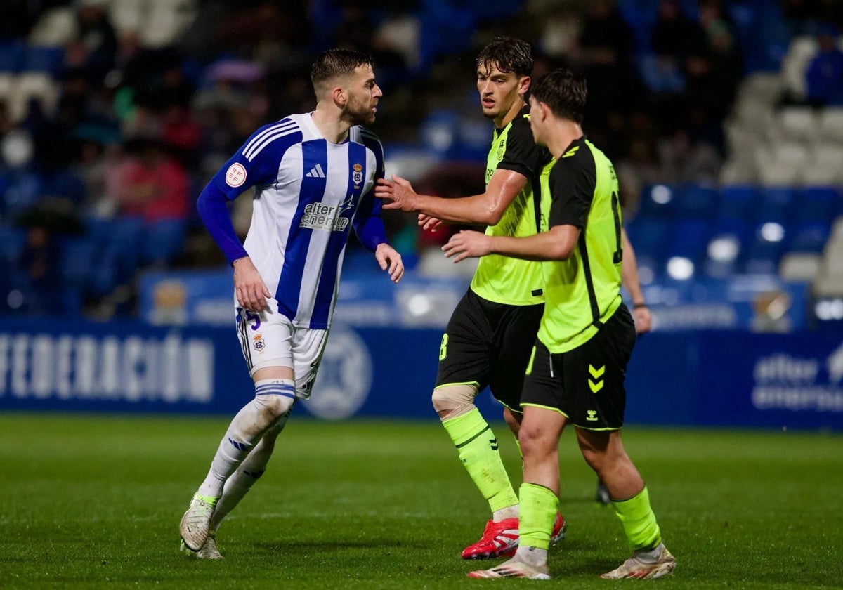 Rafa Gálvez junto a dos adversarios durante el Recreativo de Huelva-Betis Deportivo