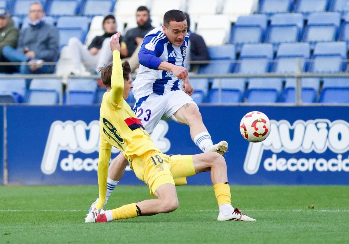 David Soto trata de poner un centro ante un rival