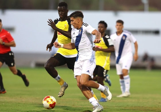 Paolo Romero conduce el balón atosigado por un rival del San Roque