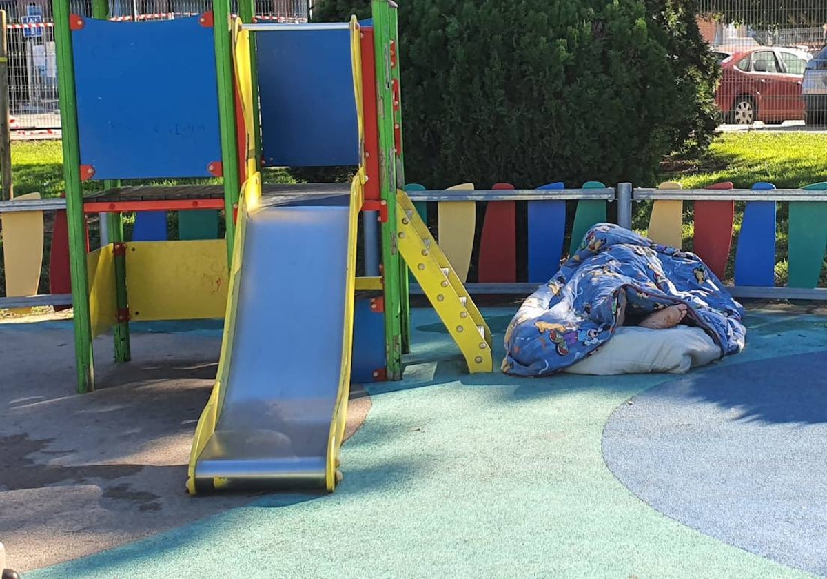 Una persona durmiendo en el parque infantil de Costa de la Luz