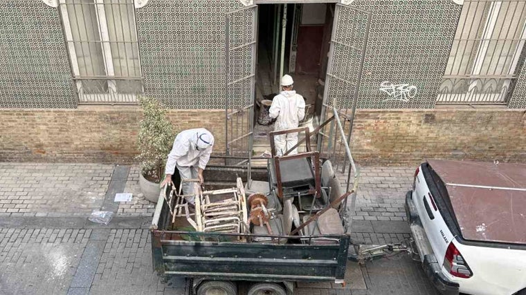 Operarios cargan en un remolque el viejo mobiliario del edificio