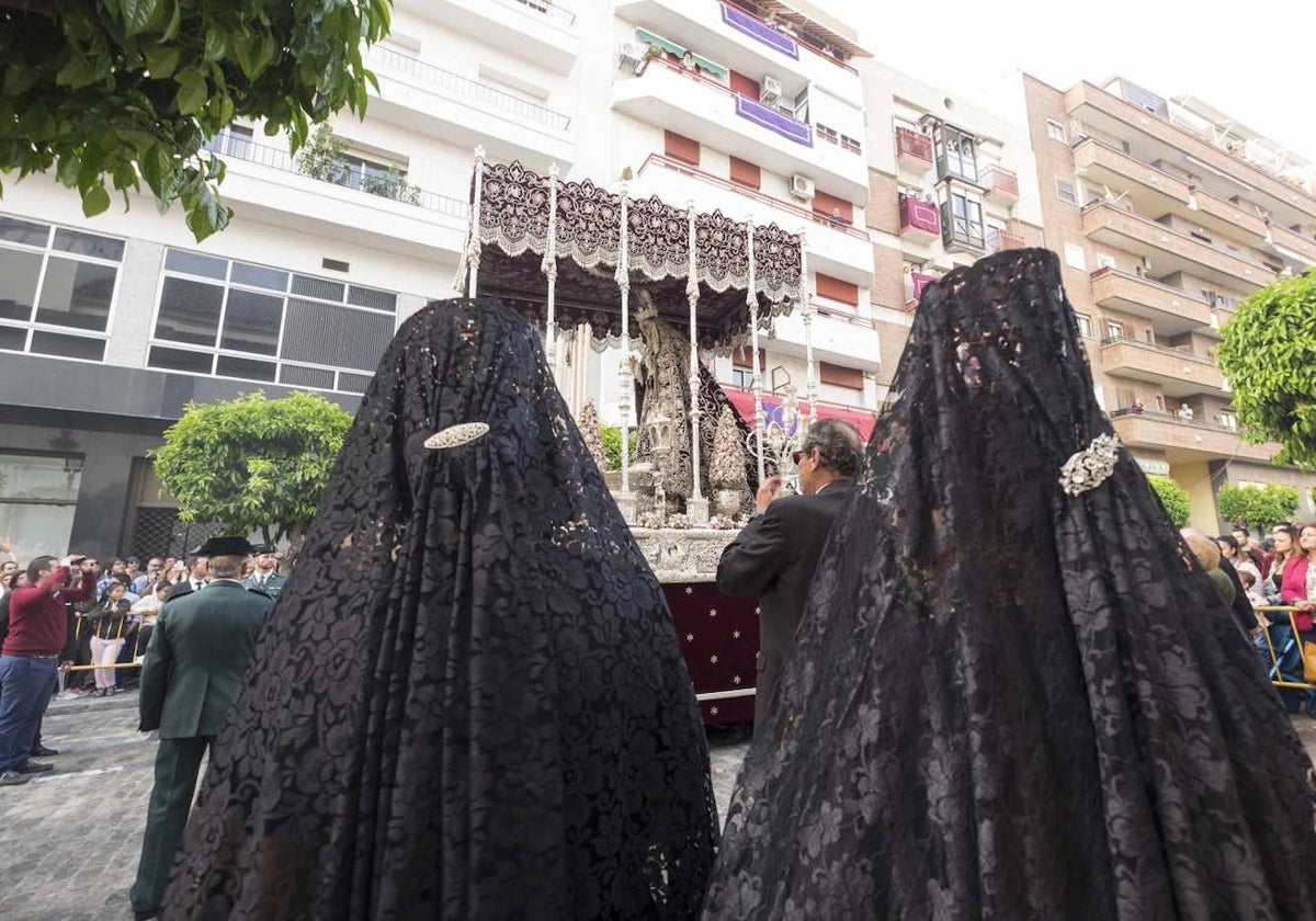 Señoras de mantilla ante el paso de palio de Nuestra Madre y Señora de los Dolores