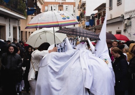 Imagen secundaria 1 - El paso de misterio del Santísimo Cristo de la Lanzada, nazarenos con paraguas y una fiel llorando