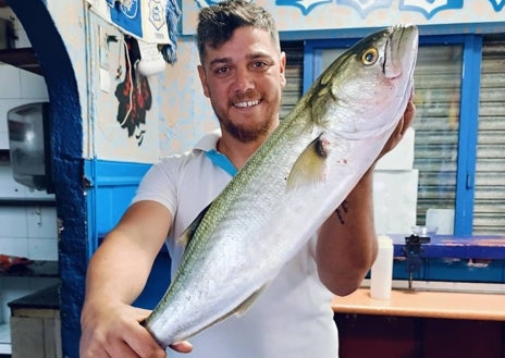 Imagen secundaria 1 - Juan en su bar Pancho demostrando su pasión por el fútbol y por la pesca, y abajo el funko que le han hecho en su honor