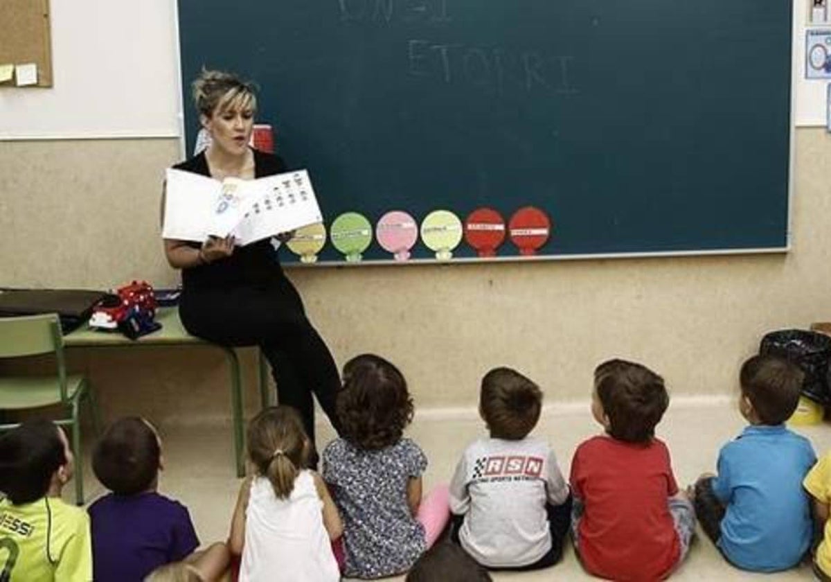 Una maestra dando clases ante la atenta mirada de sus alumnos de Infantil