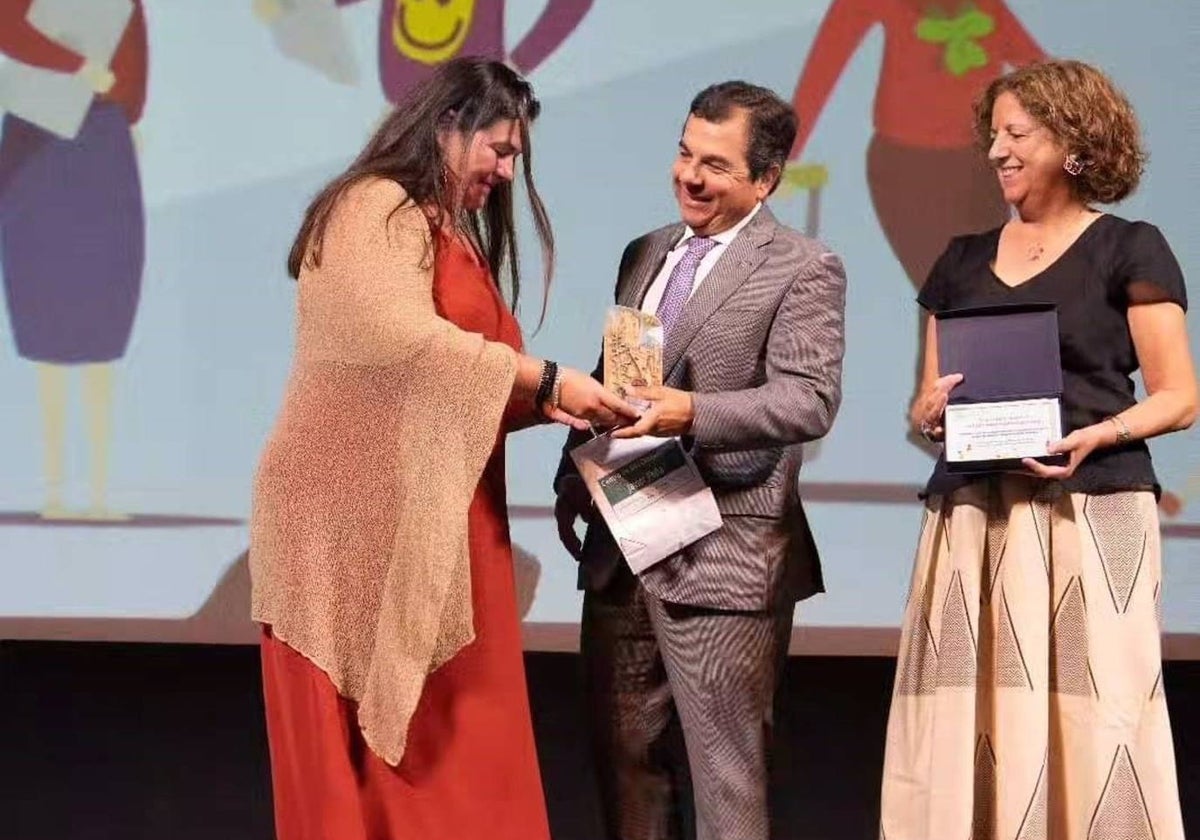 La directora de Cáritas Diocesana de Huelva, María Macías, recoge el premio
