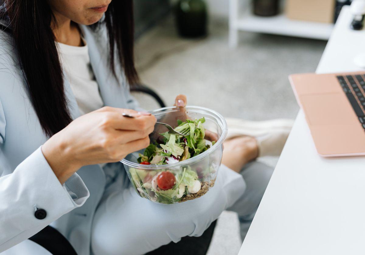 Imagen de una mujer comiendo durante el trabajo
