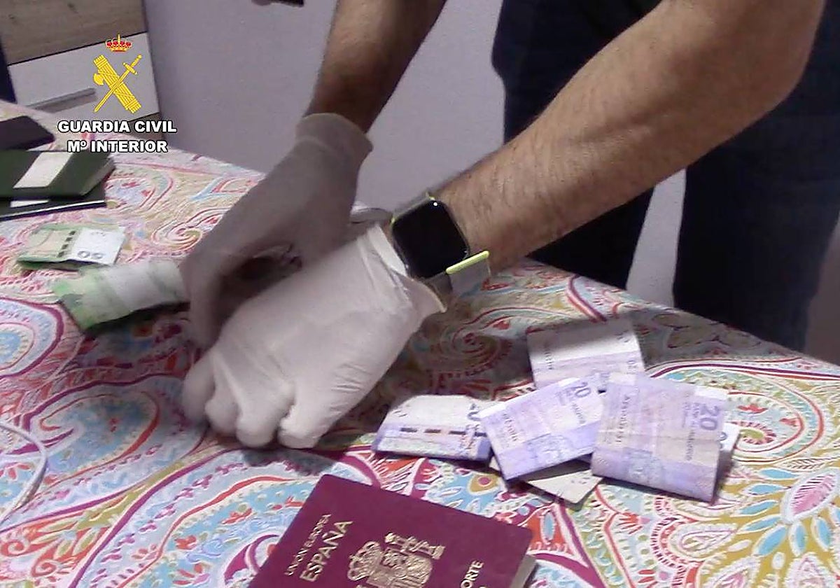 Agente de la Guardia Civil, con dinero y documentación falsa, durante un registro