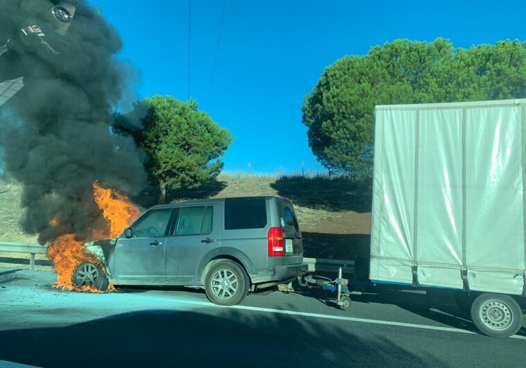 El coche con remolque incendiado en la carretera