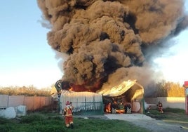 Un incendio en un tractor de una nave de plásticos de Moguer provoca una intensa columna de humo visible desde varios puntos de Huelva