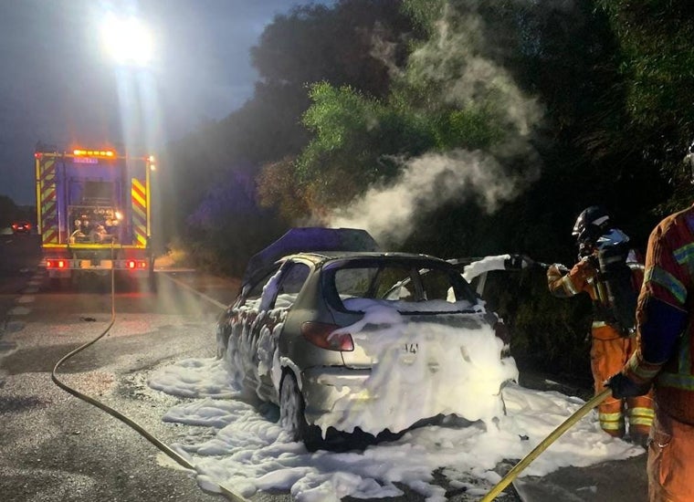 Los bomberos sofocando las llamas de un vehículo que se había incendiado de madrugada en Almonte