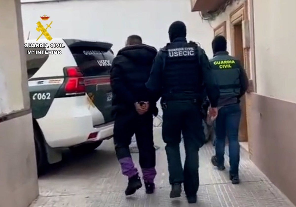 Agentes de la Guardia Civil, con uno de los detenidos en Isla Cristina