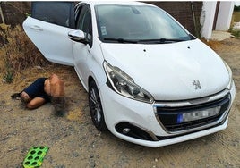 La víctima junto al vehículo donde fue encontrado en el término municipal de Lepe