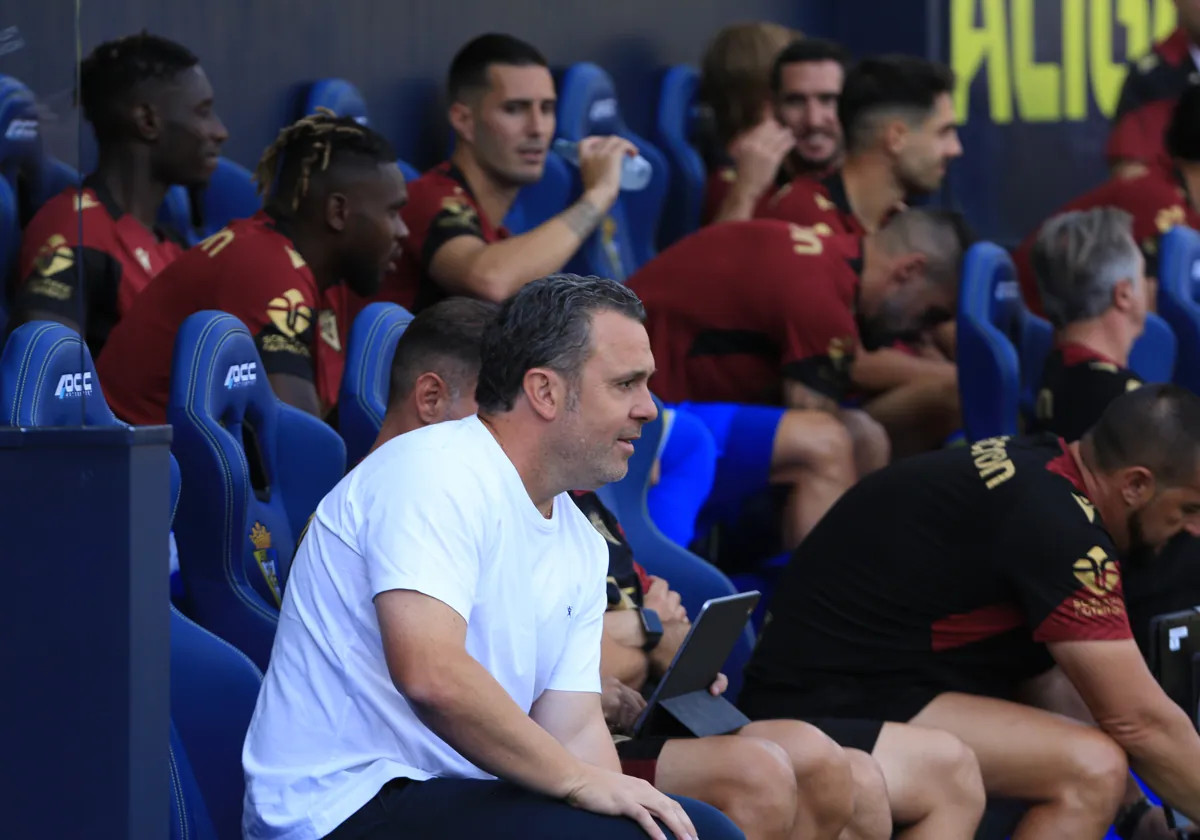 Sergi Guardiola, en el banquillo, mira de soslayo a Sergio mientras bebe agua.