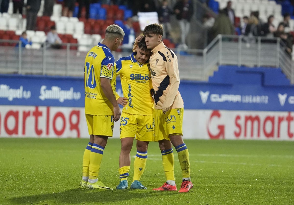 Óscar Melendo es consolado por sus compañeros Brian Ocampo y De la Rosa al término del encuentro en Eibar.