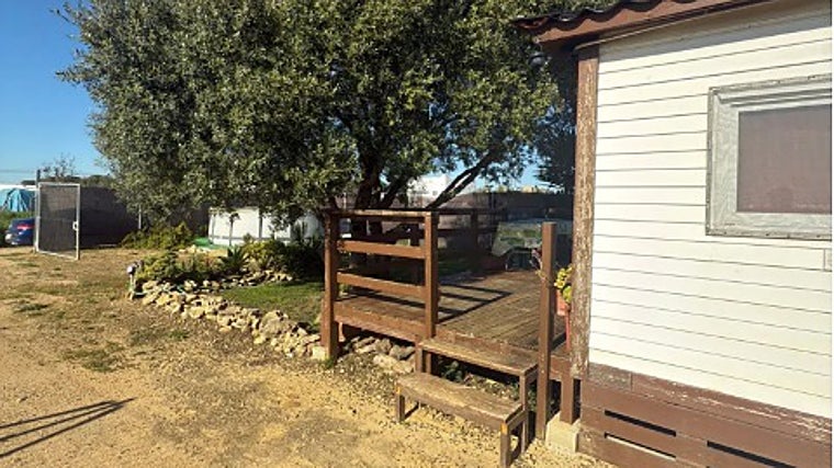 La parcela tiene una mobile home ubicada muy cerca de un gran árbol