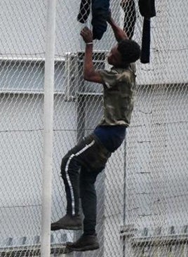 Imagen - Tres agentes y un inmigrante en pleno salto