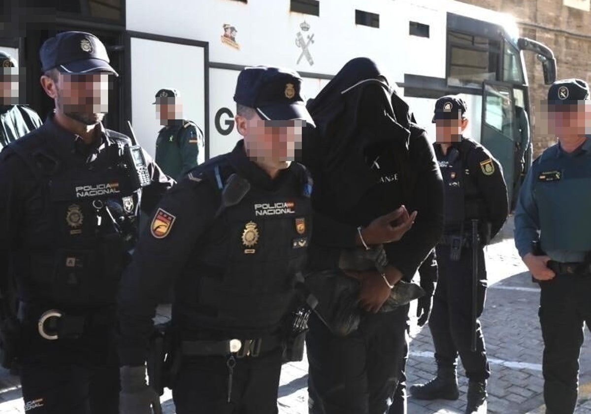 Uno de los procesados entra en la Audiencia custodiado por Policía Nacional y Guardia Civil.