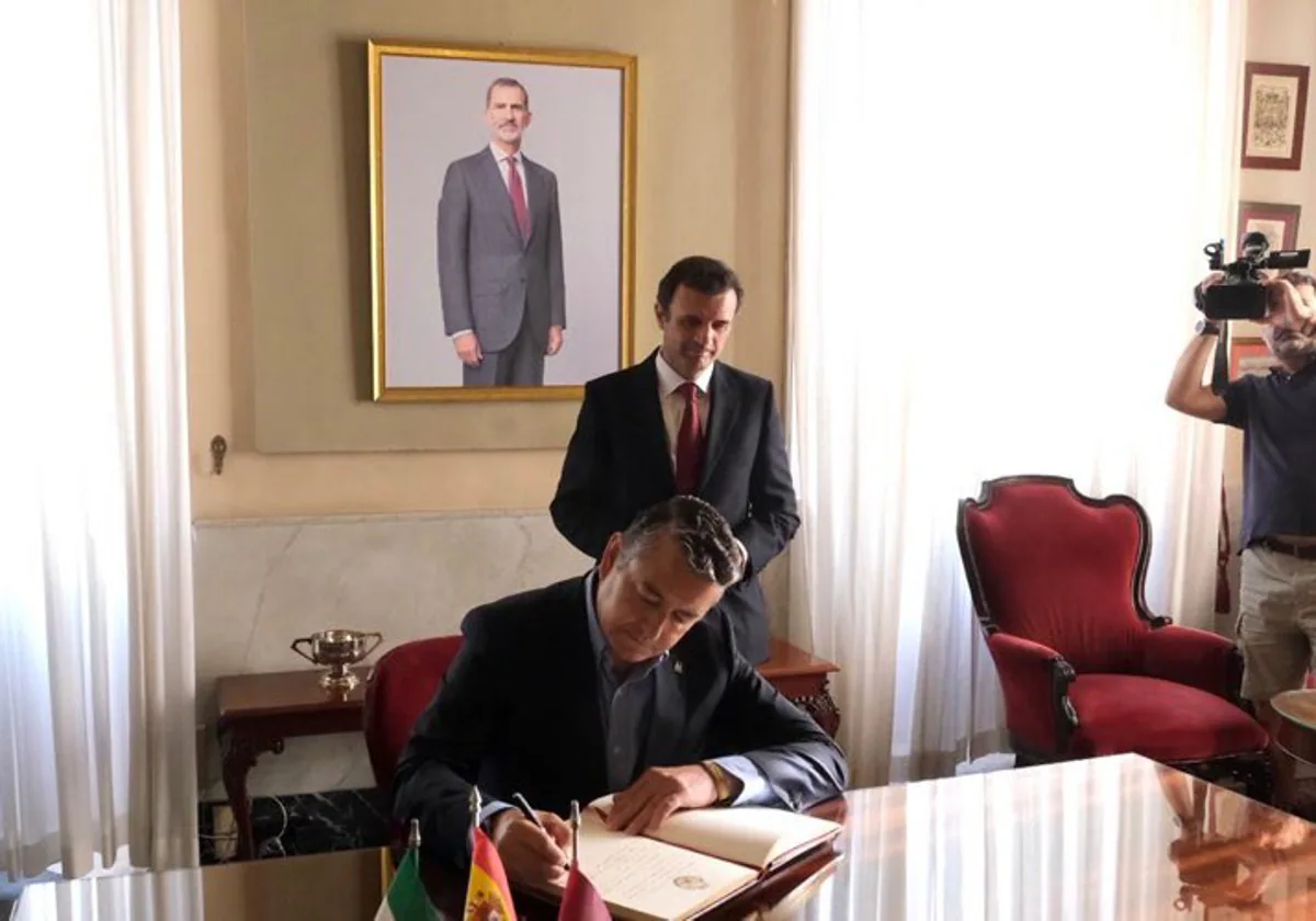 Antonio Sanz firma en el libro de visitas del Ayuntamiento en presencia del alcalde, Bruno García.