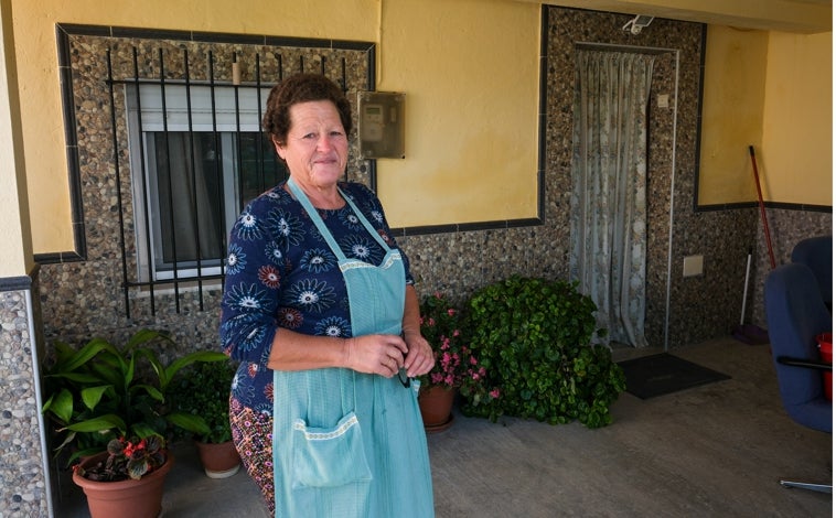 Imagen principal - María posa en el porche de su casa, la misma que se inundó, como se puede apreciar en la foto de abajo. En las huertas saben que la lluvia es necesaria este otoño