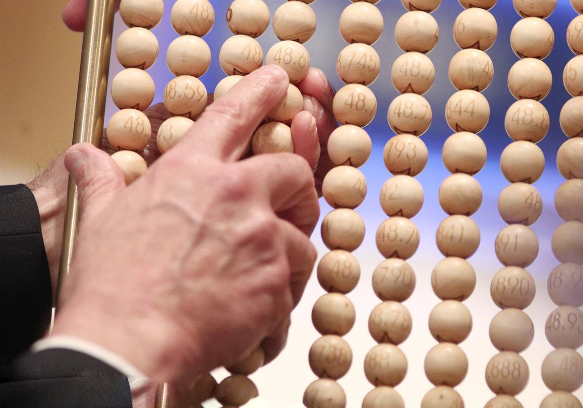 Unos de los lotes de alambres con bolas de los números antes de introducirse en el bombo grande durante el sorteo
