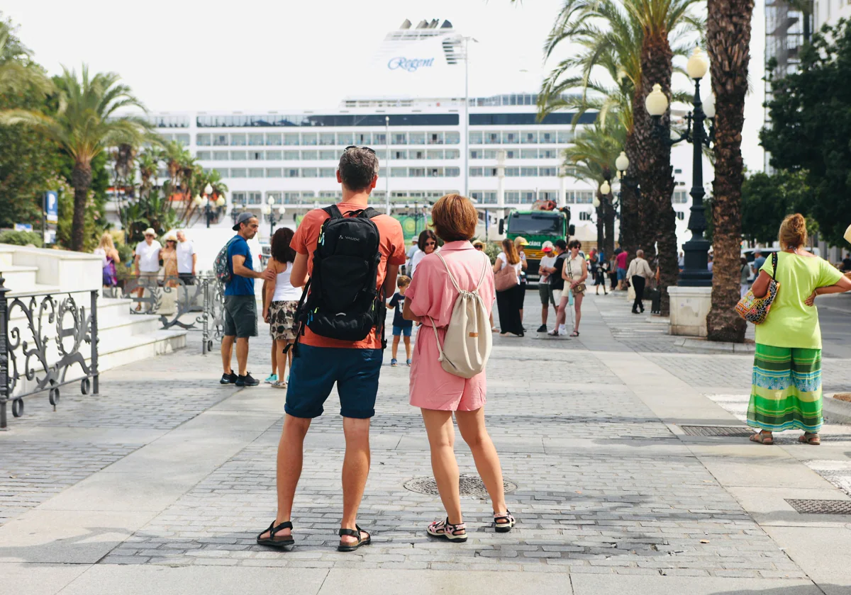Dos turistas observan un crucero atracado en el Muelle Ciudad de Cádiz