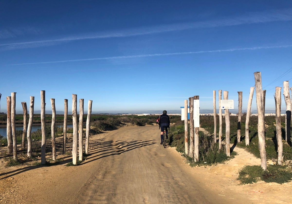 Un ciclista atraviesa la entrada de Chiclana del sendero del Eurovelo 8.