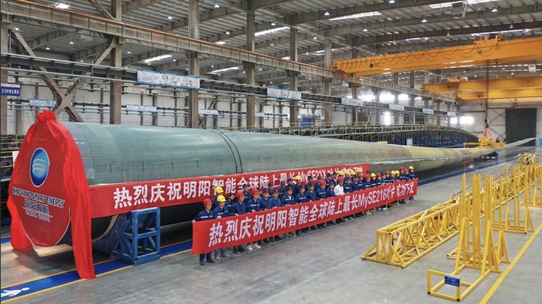 Trabajadores de la empresa china Minyang posan junto a una de las palas que han construido