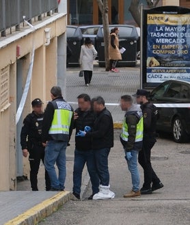 Imagen secundaria 2 - Impacto de bala en la puerta del garaje y en un coche que estaba frente a este aparcamiento. Y los agentes de Policía, en el lugar. 