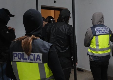 Imagen secundaria 1 - Uno de los detenidos es trasladado a calabozos. Los agentes en el domicilio registrado. 