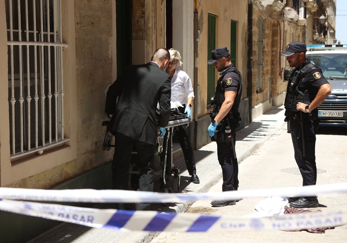 Los servicios funerarios trasladan el cadáver.