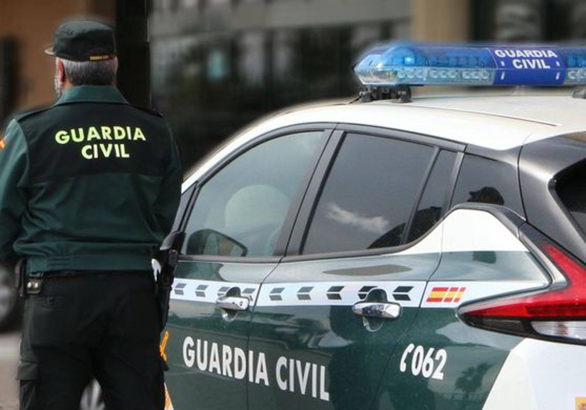 Un agente de la Guardia Civil junto a un vehículo oficial.