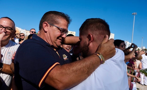 Un padre abraza a su hijo nada más bajar del barco.