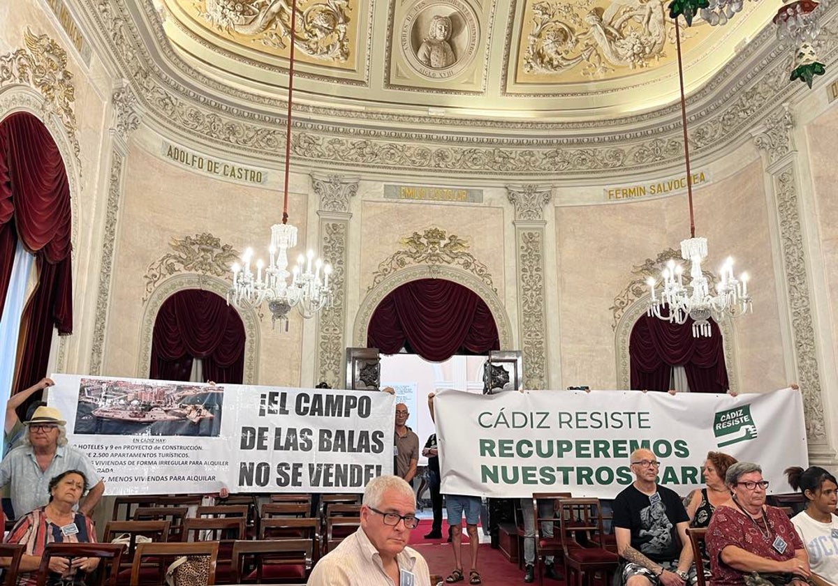 Pancartas mostradas este viernes en el Salón de Plenos del Ayuntamiento de Cádiz