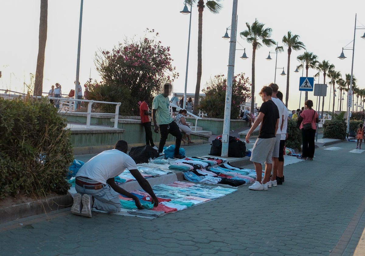 Un grupo de jóvenes compran ropa en el paseo marítimo de Valdelagrana