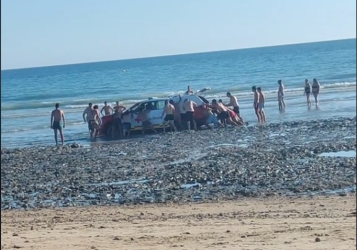 Un coche de la Cruz Roja queda atrapado en el fango de la playa de Camposoto, en San Fernando