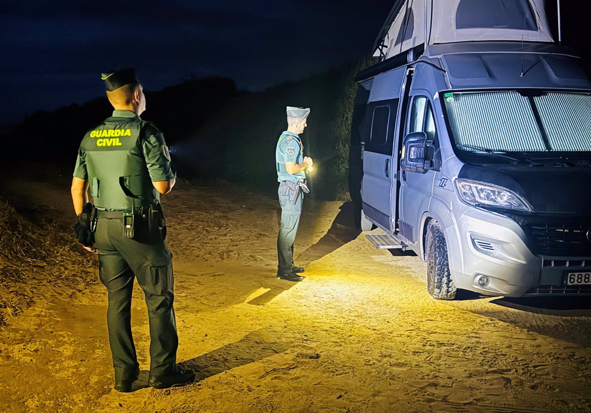 Agentes de la Guardia Civil junto a una de las autocaravanas desalojadas en Tarifa