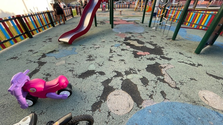 Un deteriorado pavimento de caucho de un parque infantil de Cádiz.