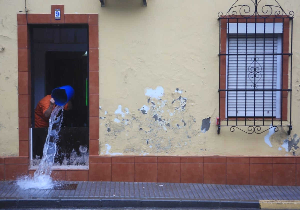 Un vecino achica agua de su casa, en San Fernando